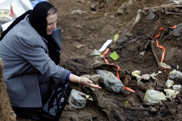 A Bosnian Muslim woman who lost her relatives looks at human remains found in a mass grave in the village of Cerska. In March of 1993, more than two years before the 1995 Srebrenica genocide, Serbs overrun the Muslim village and slaughtered up to 250 Bosniak women, children and the elderly men.